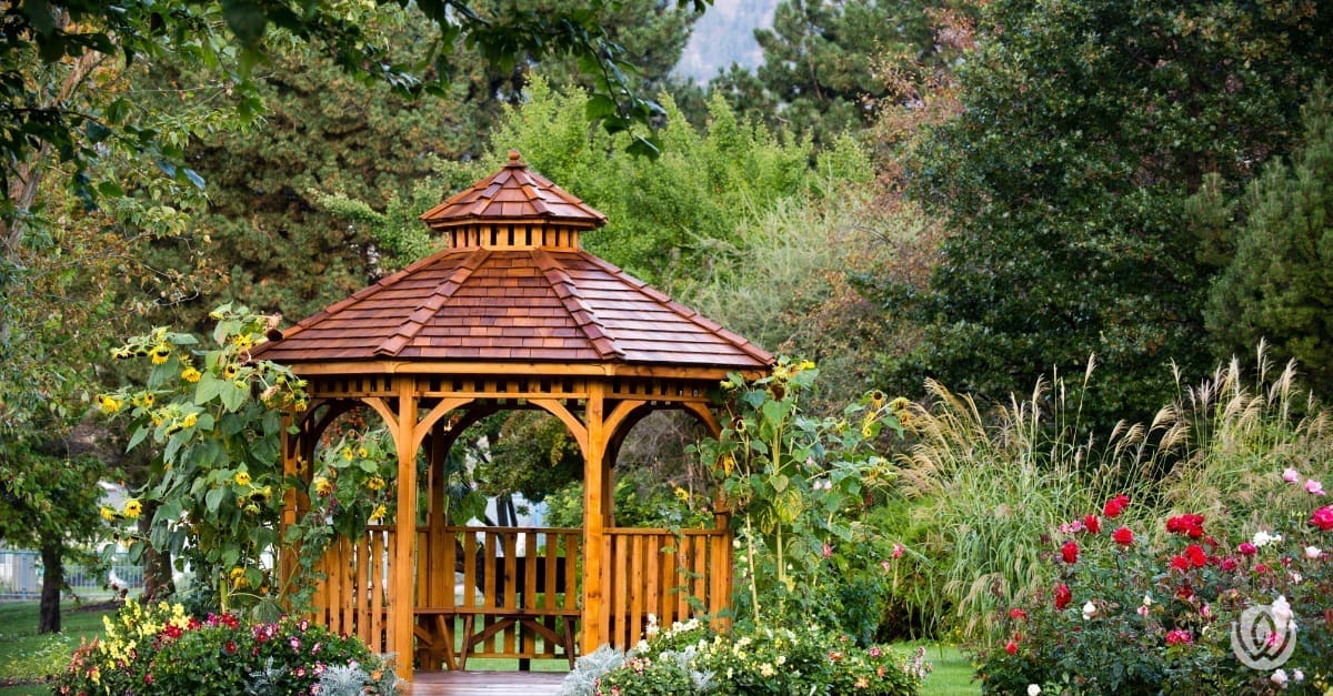 Backyard gazebo with wood roof and decorative plants