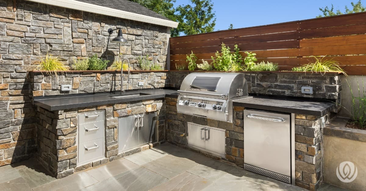 Custom outdoor grill station with stone base and stainless steel appliances
