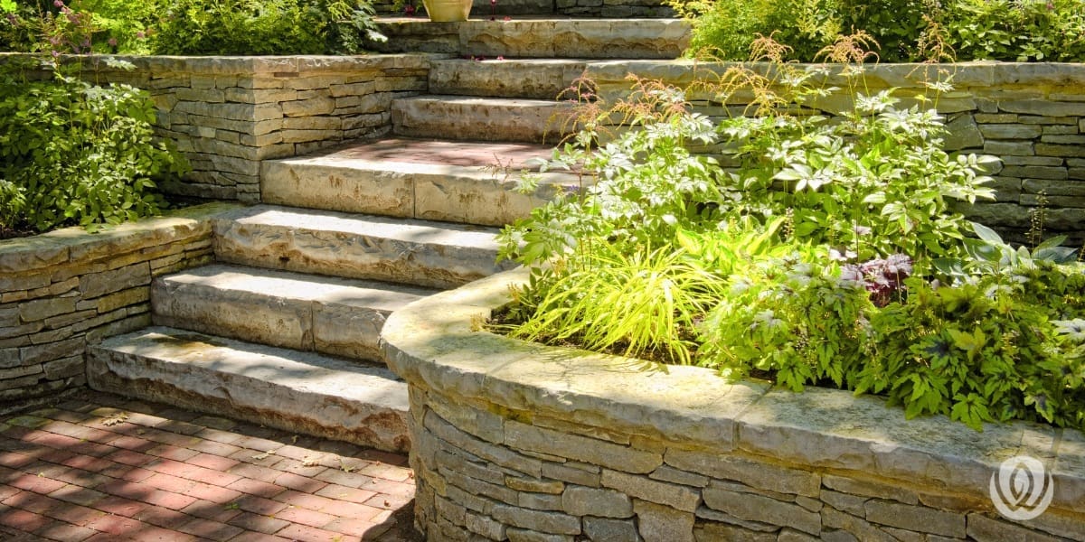 Curved stone retaining wall with integrated garden beds and stone steps